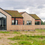 Træfacade på hus i Skovhusene, opført med træelementer og moderne arkitektur.